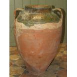 An old terracotta jar with green glazed neck moulded loop handles and combed detail, 60 cm high