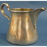 A silver Garrard & Co milk jug with a scrolled handle, London 1910, 9.2 oz