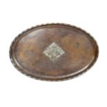 An Arts and Crafts hammered copper and white metal oval tray by Hugh Wallis with central foliate