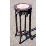 A late 19th century Chinese hardwood jardinière stand, the octagonal top with marble inset and