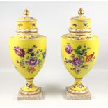 A pair of early 20th century German porcelain vases and covers, each printed with floral sprays on a