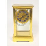 An early 20th century brass mantle clock, the circular dial with blue enamel Arabic numerals