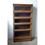 A Globe Wernicke oak 5 sectional bookcase with ogee base drawer, W. 86 cm