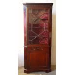 A Late George III mahogany corner cupboard, in two parts, the top section with moulded cornice and