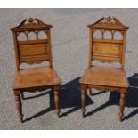 A pair of late Victorian oak hall chairs with spindle back, on ring turned legs to the front (2)