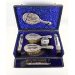 Edward VII matched silver mounted dressing table set with embossed floral and scroll decoration,