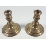 Pair of Harrods circular candlesticks, each with a baluster column, on a stepped base, by RW