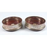 Pair of silver circular coasters, each with a turned mahogany base, by J Bull Ltd, London 2009, D