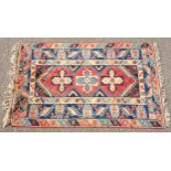 Turkey rug, the madder and indigo field with a row of 3 cruciform medallions within a floral border,
