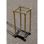 Victorian brass stick stand with grid top of 4 divisions and finials, set on a cast iron drip tray