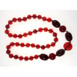 Cherry coloured spherical and oval bead necklace, L.78cm, 102.3grs