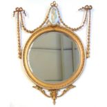 Late 19th century Neoclassical gilt wood round mirror, with bevelled glass, surmounted with swags