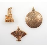 Yellow metal Disney castle charm stamped 14K, and 2 other charms stamped 14K, 10.8grs. (3)