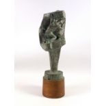 Bronzed resin abstract sculpture as a giant nail of a miner kneeling in a rock crevice, on a teak