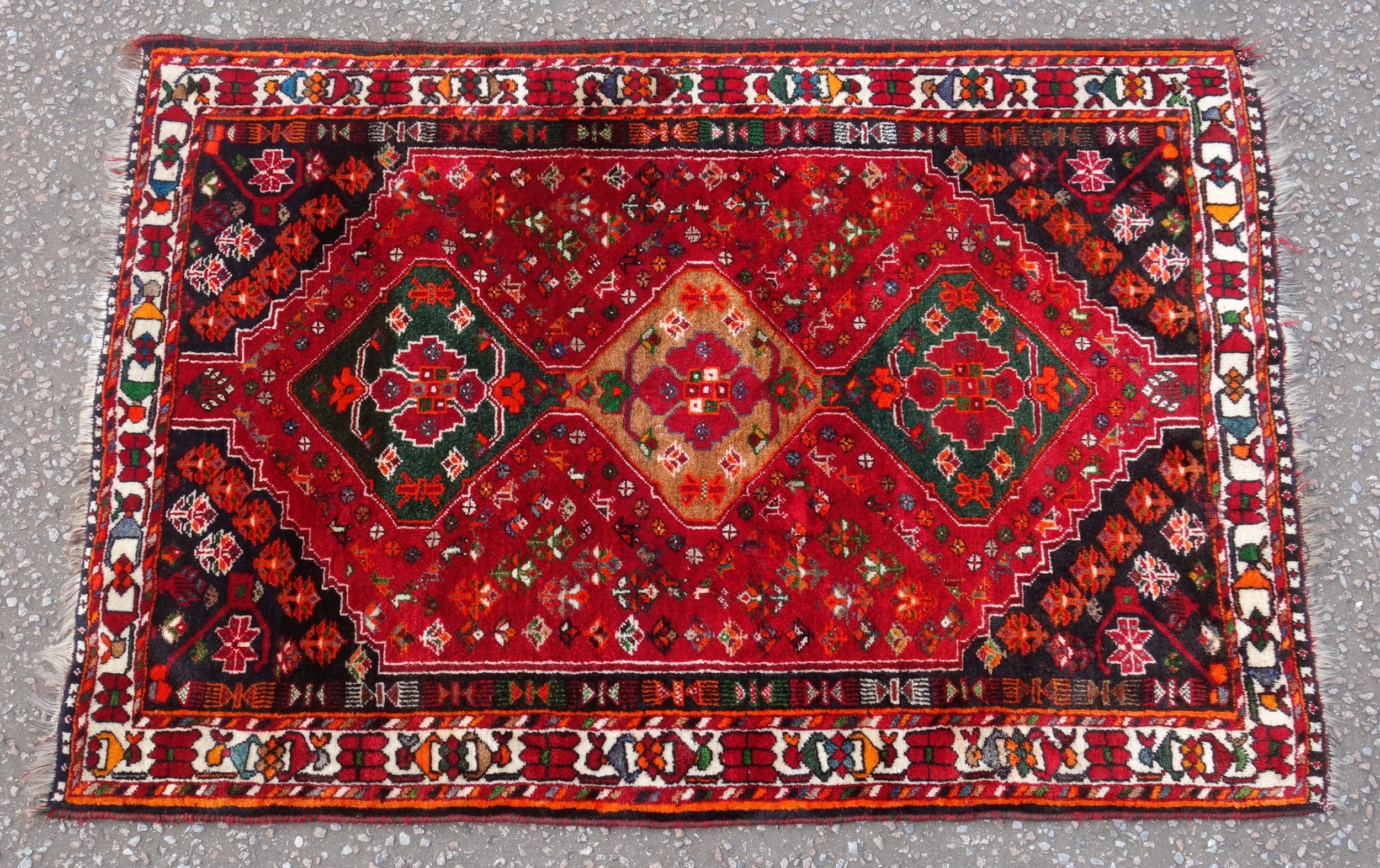 Persian rug, the madder field field with a triple lozenge medallion and all-over stylised floral