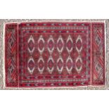 Persian Bokhara pattern rug, the madder field with 2 rows of hexagons and stylised floral