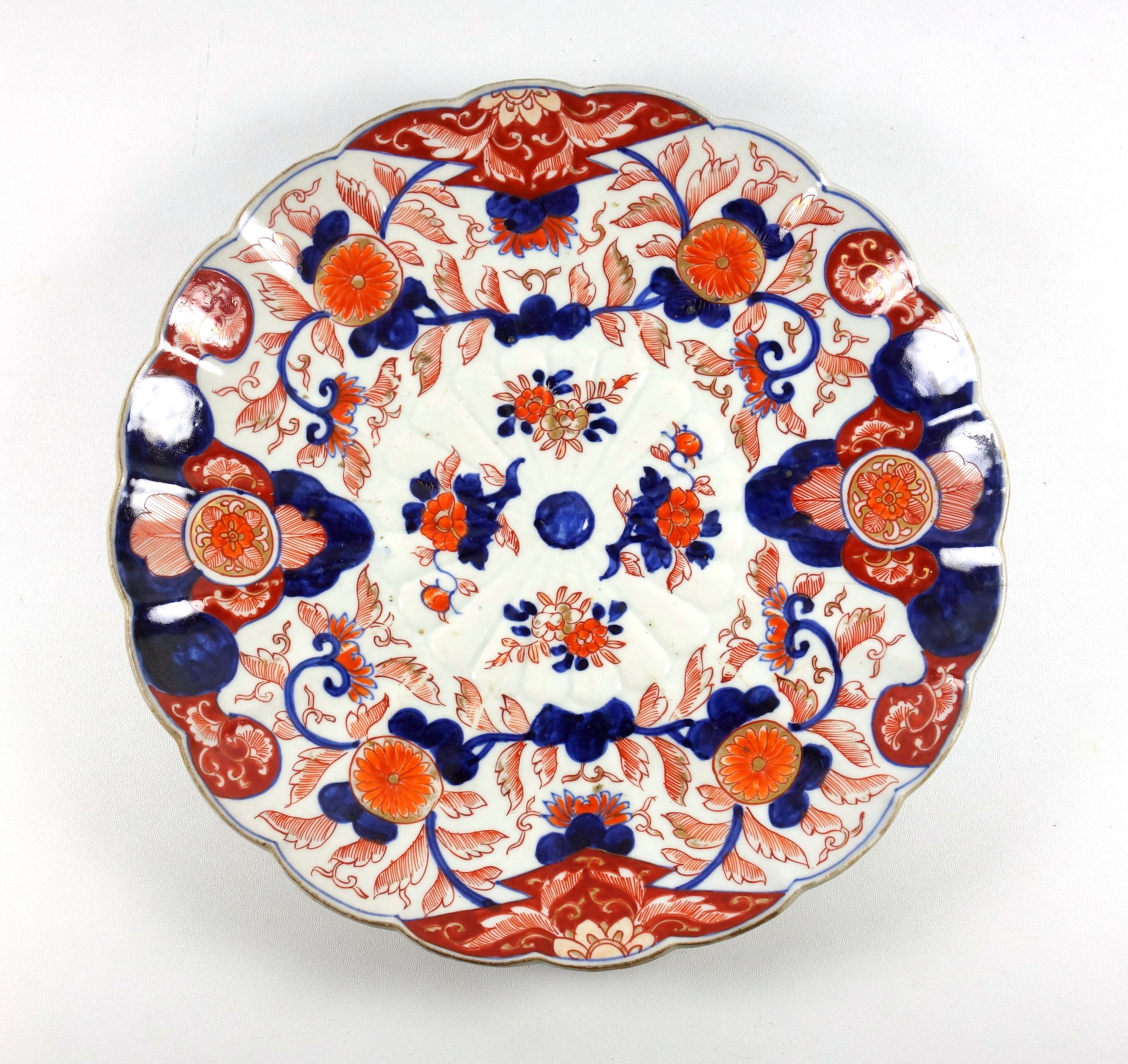 Late 19th Century Japanese porcelain fluted saucerdish with painted blue and red Imari floral