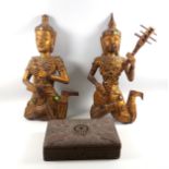 Two Indian carved giltwood wall hanging Buddha figures playing musical instruments, decorated with