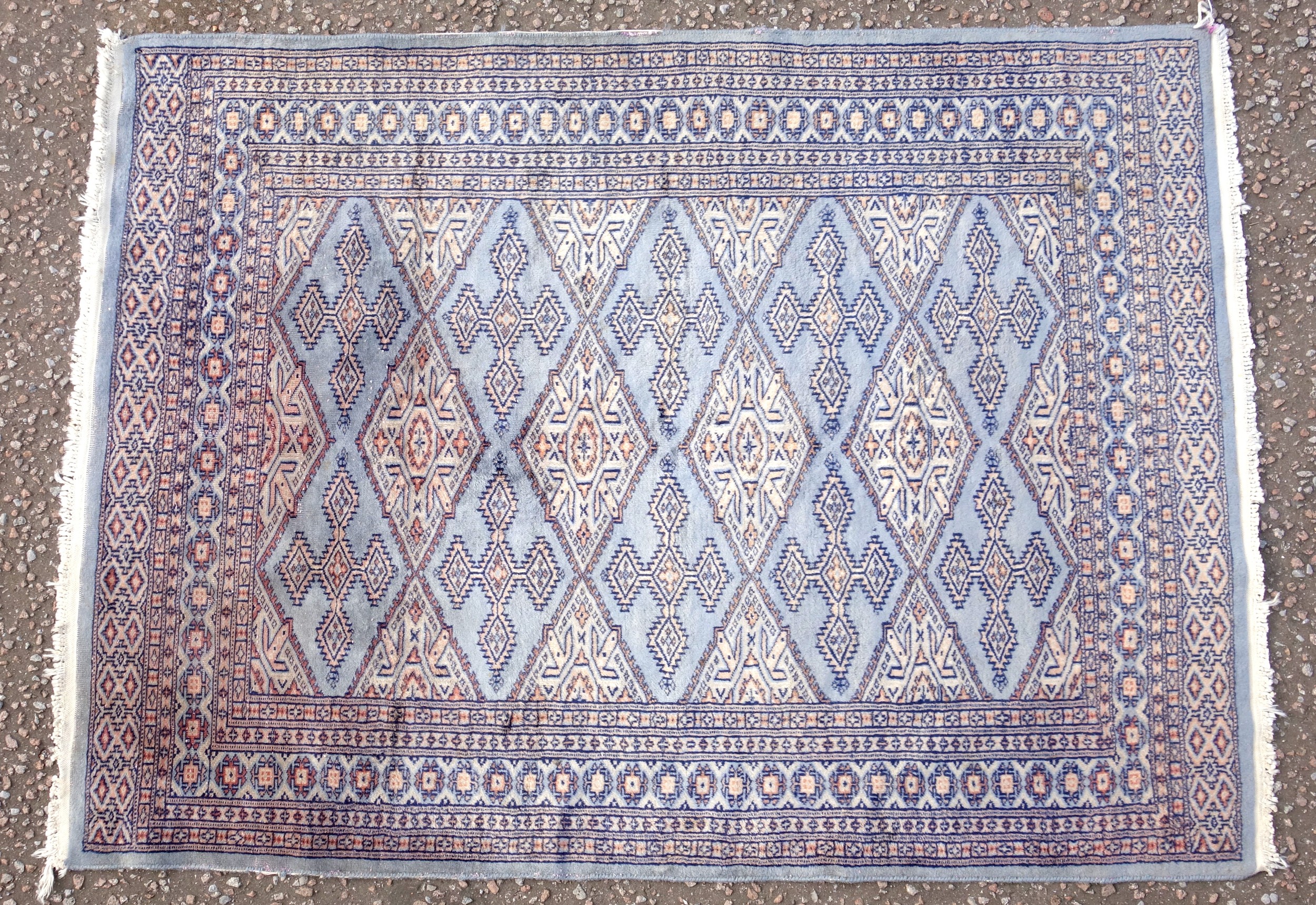 Persian Bokhara pattern pink field rug with 3 rows of hexagons, and stylised floral decoration,