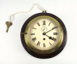 A brass ship's bulkhead clock, with Roman numeric ivory coloured dial and inset seconds dial with