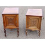 Pair of late Victorian walnut bedside tables, each with a craved floral panelled door, on turned