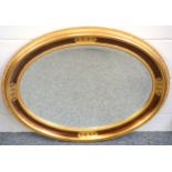 Oval bevelled glass mirror in a giltwood frame with lattice and c-scroll decoration, and a moulded