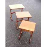 Nest of 3 mid century teak coffee tables, each with a rectangular top, on shaped end supports, the