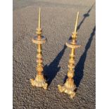 Pair of Italian carved giltwood altar candlesticks, each with a baluster column, on 3 scroll feet,