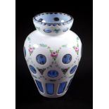 Bohemian white overlay glass baluster vase, with painted floral decoration and blue tinted roundels,