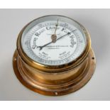 A BRASS ANEROID BAROMETER, T. REYNOLDS AND SON