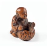 A JAPANESE BOXWOOD 'BOY AND LOTUS' NETSUKE, MEIJI PERIOD, 1868 - 1912