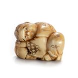 A JAPANESE IVORY NETSUKE OF A RECUMBENT FIGURE, MEIJI PERIOD, 1868 - 1912