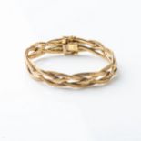 A MULTI STRAND GOLD BRACELET 4 strands in a cross-over design, 10cm wide, 18cm in length, hallmarked