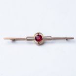 A GEM-SET BROOCH Claw-set to the center with a round brilliant-cut gemstone, possibly ruby, in an