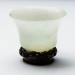 A CHINESE HARDSTONE WINE CUP The bell-shaped cup raised on a short foot, carved from a translucent
