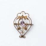 A GEM SET BROOCH Claw-set to the center with an oval faceted gemstone, in delicate wire frame with a