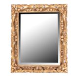 A CARVED GILTWOOD WALL MIRROR, 20TH CENTURY The rectangular frame carved and pierced rocaille and