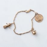 A GOLD CHARM BRACELET  Complete with 3 charms including a St Christopher figure, a jack-in-the-
