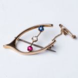 A GOLD BROOCH Claw-set with a sapphire, ruby and diamond in a wishbone design, in 14ct gold, 3cm