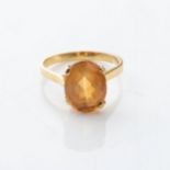 A GEMSTONE RING Claw-set to the center with an oval brilliant-cut gemstone, possibly a topaz, in a