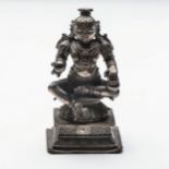 A SILVERED COPPER ALLOY FIGURE OF AN INDIAN DEITY Seated on a lotus throne holding an orb and vessel