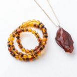 A SUITE OF AMBER JEWELLERY Including: a necklace and a pendant on a gold chain, 50cm in length (2)