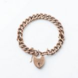 A GOLD CHARM BRACELET Curb link, with padlock and safety chain, 18cm in length