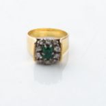 AN EMERALD RING Claw-set to the center with a single emerald surrounded by diamonds, in a raised