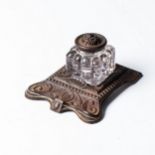 AN ENGLISH GLASS AND CAST IRON INKWELL, CIRCA 1908