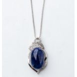A TANZANITE AND DIAMOND PENDANT Claw-set to the center with an oval cabochon tanzanite weighing