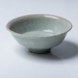 A CHINESE CELADON GLAZE BOWL The deep rounded sides rising to a flaring rim from a high foot, the