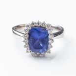 A TANZANITE AND DIAMOND RING Claw-set to the center with an emerald-cut tanzanite weighing