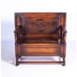 AN OAK MONKS BENCH, EARLY 20TH CENTURY Convertible to a table with adjustable back panel the