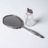 AN INDIVIDUAL A SILVER HAND HELD MIRROR AND TOPPED COLOGNE BOTTLE  The hand held mirror and